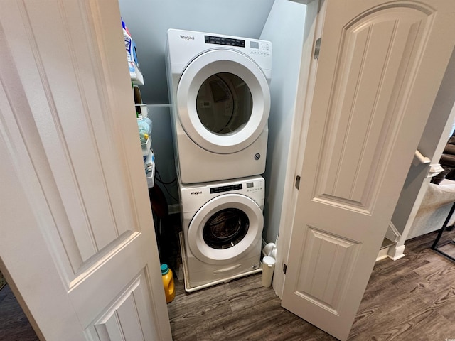 washroom featuring stacked washing maching and dryer and dark hardwood / wood-style floors