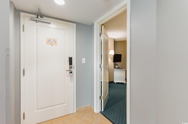 interior space with light tile patterned floors and a textured ceiling