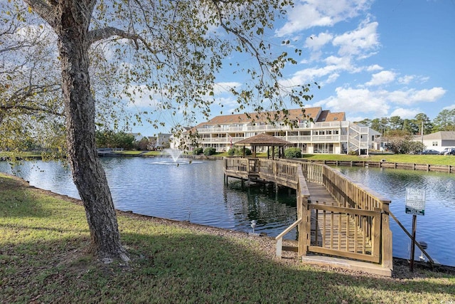 view of dock with a water view and a yard