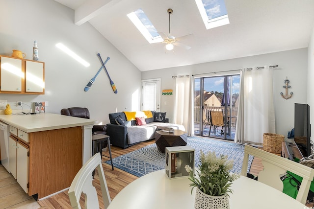 interior space featuring high vaulted ceiling, a skylight, ceiling fan, light wood-type flooring, and beam ceiling