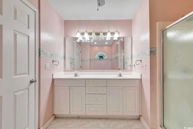 bathroom featuring tile patterned flooring, vanity, a textured ceiling, and an enclosed shower