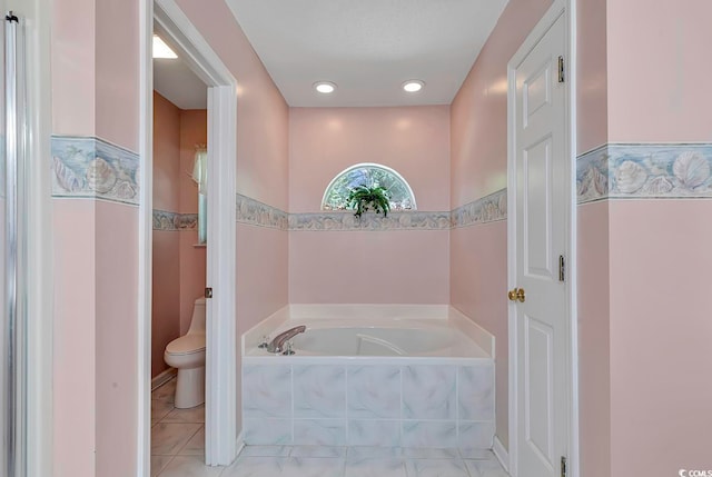 bathroom featuring toilet and tiled tub