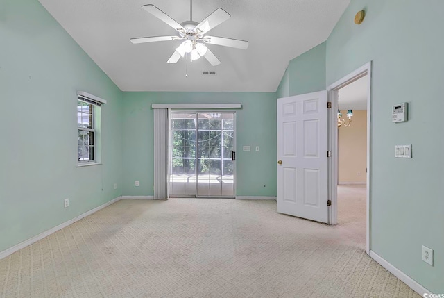 unfurnished room featuring ceiling fan with notable chandelier, light colored carpet, and vaulted ceiling