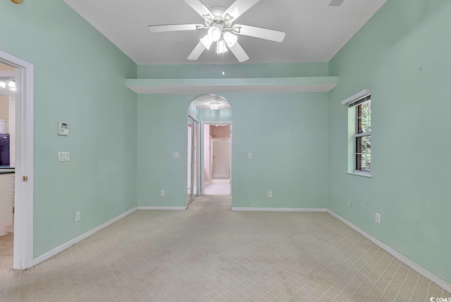 spare room with ceiling fan and light carpet