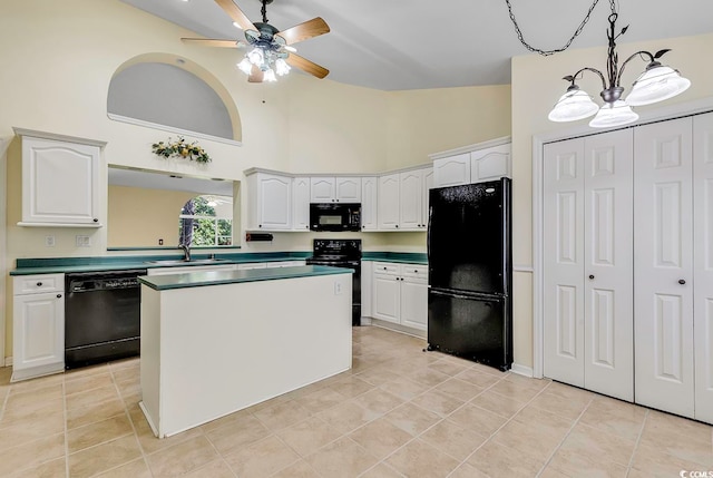 kitchen with black appliances, decorative light fixtures, and white cabinetry