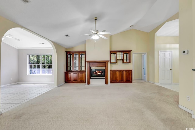 unfurnished living room with ceiling fan, light colored carpet, lofted ceiling, and ornamental molding