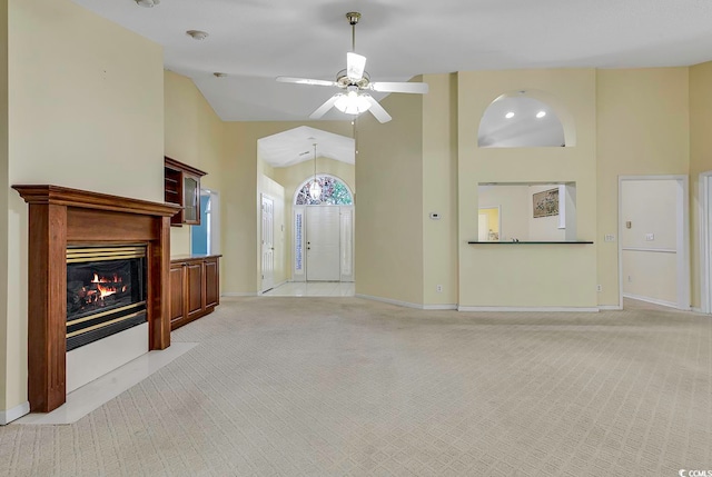 living room featuring ceiling fan, high vaulted ceiling, and light colored carpet