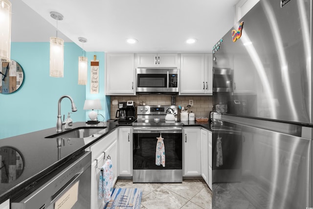 kitchen with white cabinetry, sink, stainless steel appliances, backsplash, and decorative light fixtures