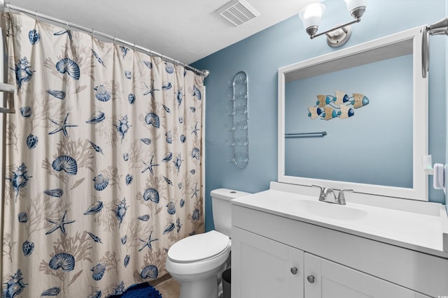 bathroom featuring curtained shower, vanity, and toilet