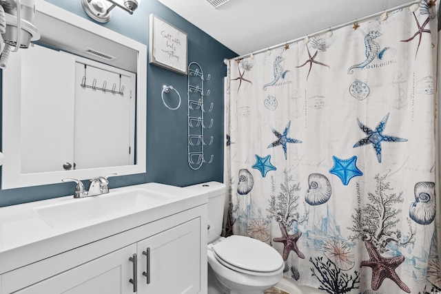 bathroom with vanity, a shower with shower curtain, and toilet