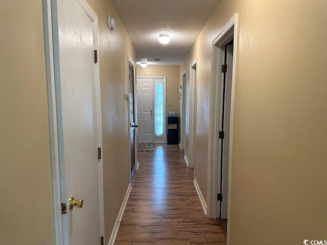 1095 W Plantation Dr Unit 28-I, Little River, SC 29566 - hallway featuring a textured ceiling, dark wood finished floors, and baseboards