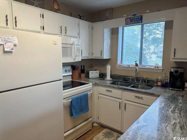 kitchen with white cabinetry, wood-type flooring, white appliances, and sink