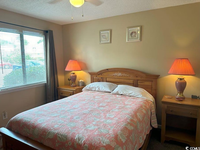 carpeted bedroom featuring ceiling fan and a textured ceiling