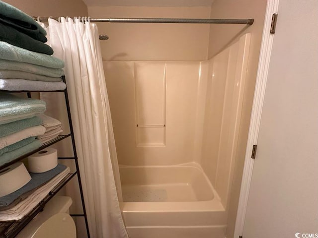 bathroom with shower / bath combination with curtain and toilet