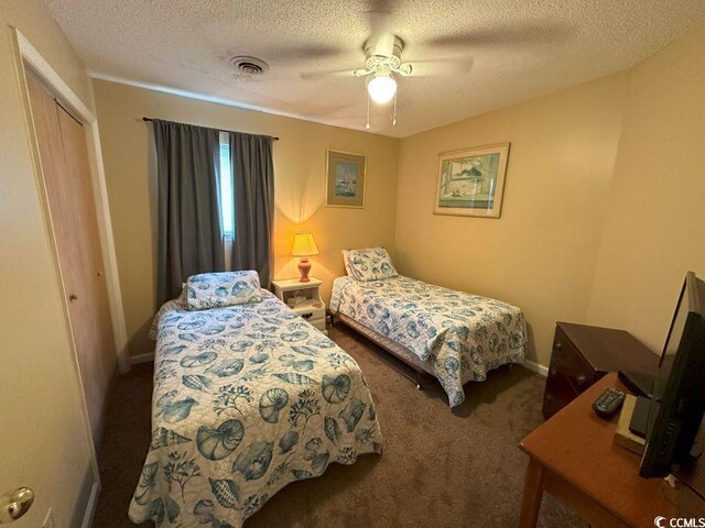 1095 W Plantation Dr Unit 28-I, Little River, SC 29566 - bedroom with carpet flooring, a closet, a textured ceiling, a ceiling fan, and baseboards