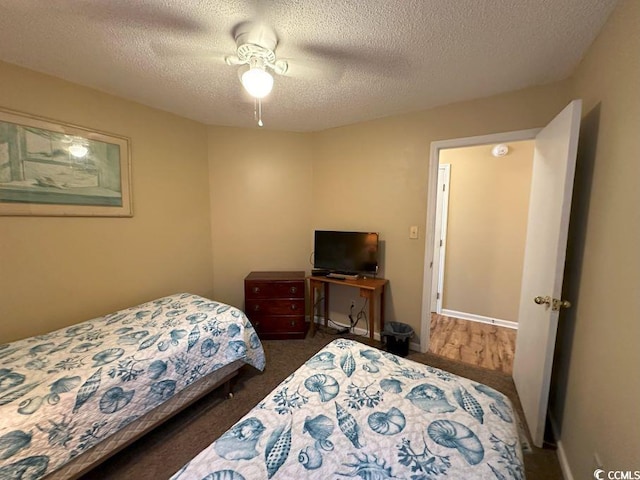 bedroom featuring ceiling fan, dark hardwood / wood-style floors, and a textured ceiling