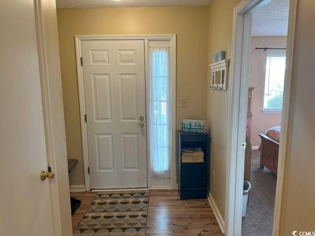 entryway with wood-type flooring and a textured ceiling