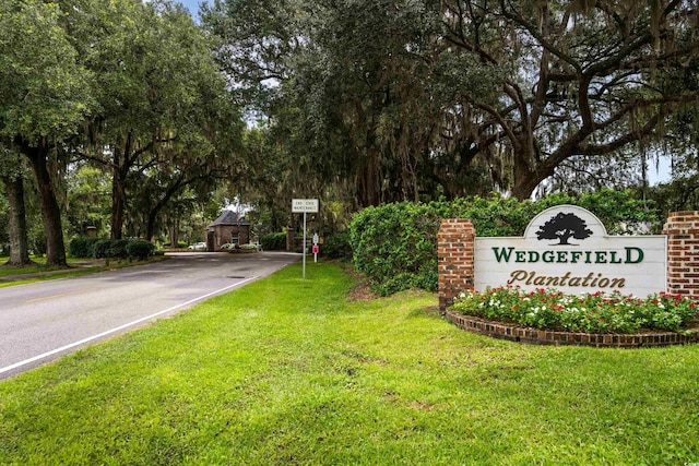 community / neighborhood sign with a yard