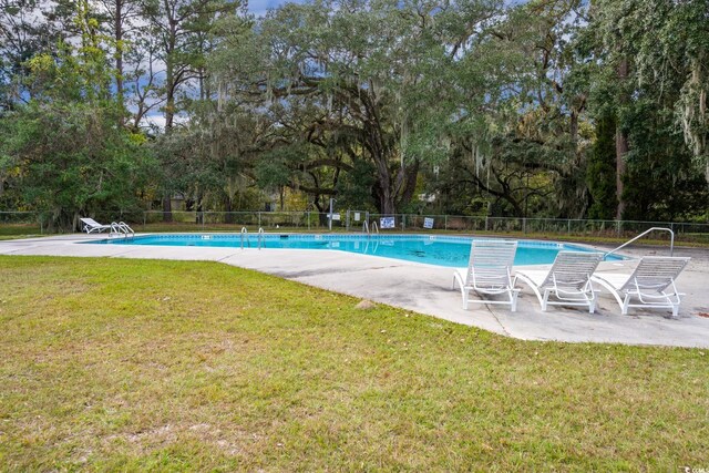 view of swimming pool with a yard and a patio