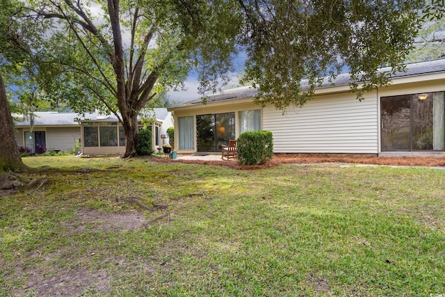 back of house with a sunroom and a yard