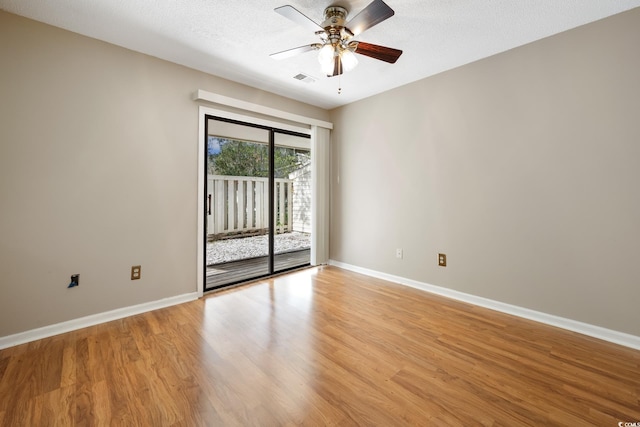 spare room with ceiling fan, a textured ceiling, and light wood-type flooring