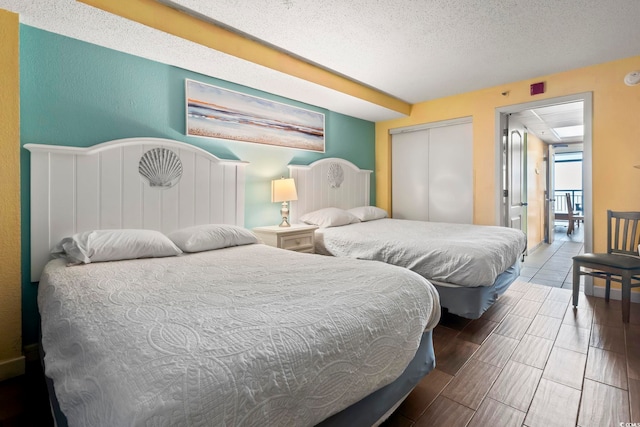 bedroom with wood-type flooring, a textured ceiling, and a closet