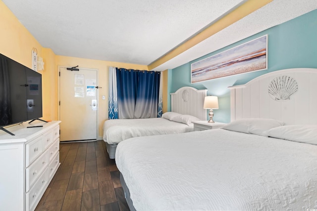 bedroom with dark wood-type flooring and a textured ceiling