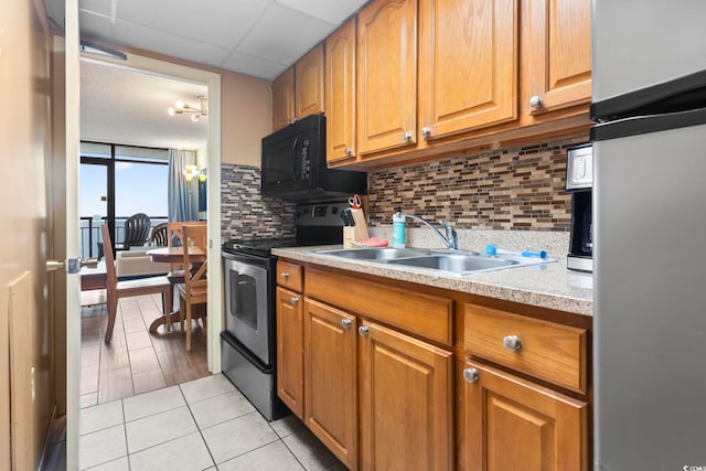 kitchen with backsplash, sink, light tile patterned floors, and appliances with stainless steel finishes