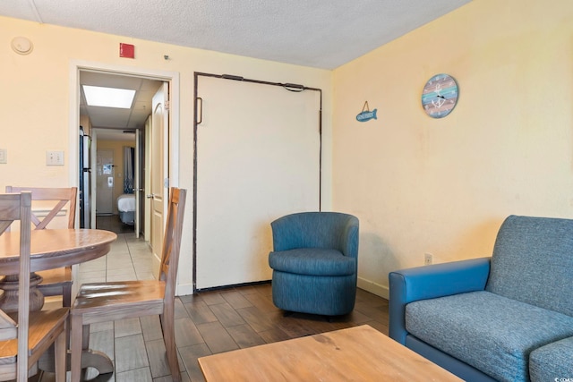 sitting room with a textured ceiling and hardwood / wood-style flooring