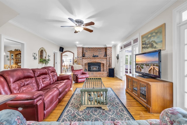 living room featuring light hardwood / wood-style floors, a wood stove, ceiling fan, and ornamental molding