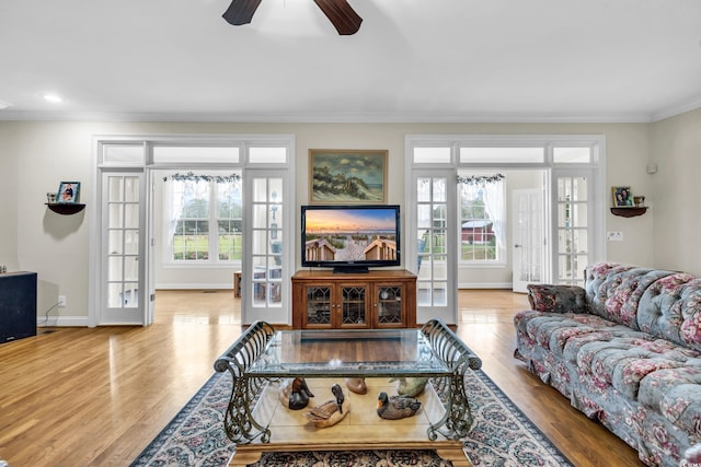 living room featuring french doors, light hardwood / wood-style floors, ceiling fan, and crown molding