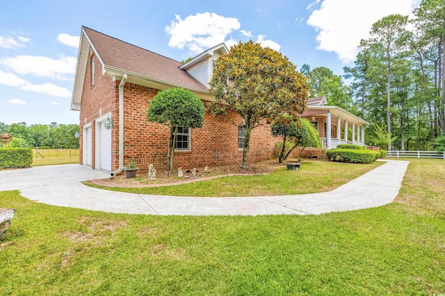 view of side of home featuring a lawn and a garage