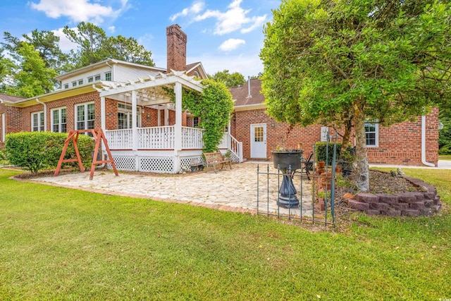 rear view of house featuring a lawn and a pergola