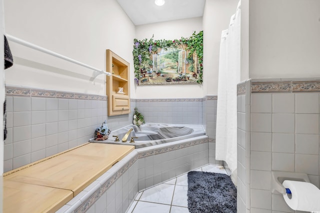 bathroom with tile patterned floors, a relaxing tiled tub, and tile walls