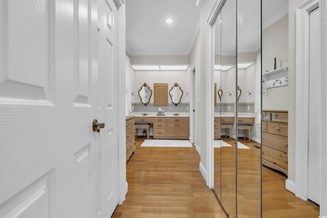 hallway featuring light wood-type flooring and ornamental molding