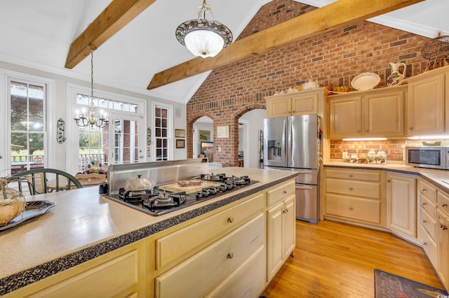 kitchen featuring crown molding, light hardwood / wood-style flooring, appliances with stainless steel finishes, decorative light fixtures, and brick wall