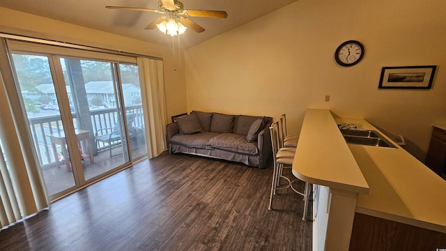 living room featuring lofted ceiling, ceiling fan, dark wood-type flooring, and sink