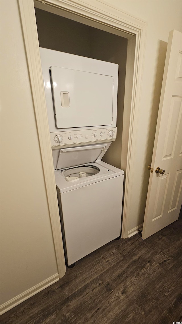 clothes washing area with dark hardwood / wood-style flooring and stacked washing maching and dryer