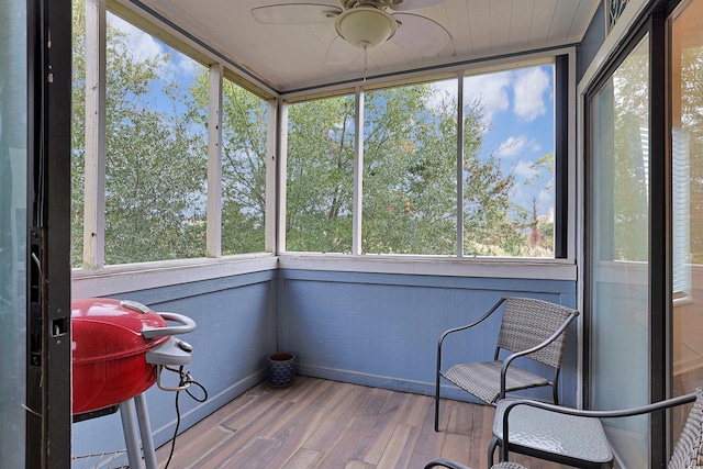 unfurnished sunroom with ceiling fan