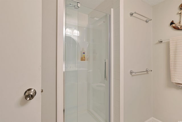 bathroom featuring a textured ceiling and walk in shower