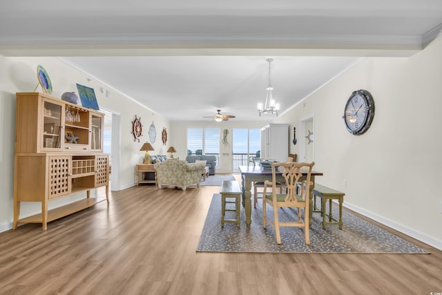 dining space with ornamental molding, ceiling fan with notable chandelier, and light wood-type flooring