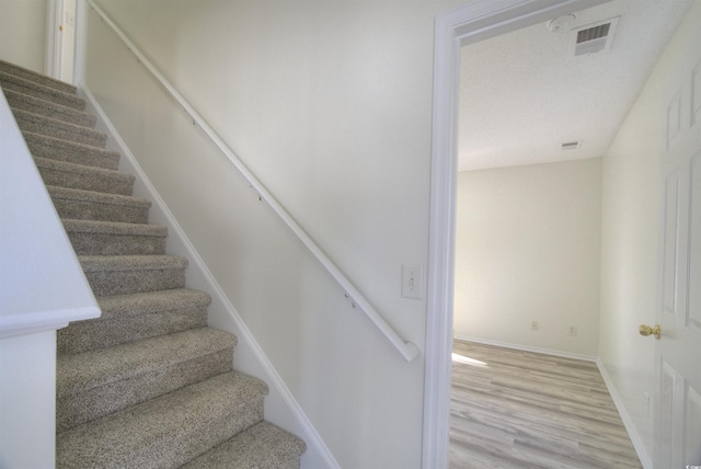 stairs featuring hardwood / wood-style flooring