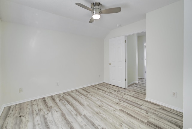 empty room featuring ceiling fan, vaulted ceiling, and light wood-type flooring