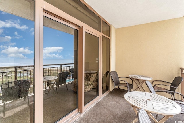 balcony featuring a water view and a view of the beach