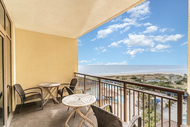 balcony featuring a water view and a view of the beach