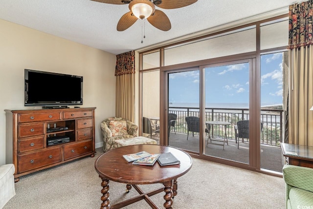 living room featuring light carpet, a water view, and a textured ceiling