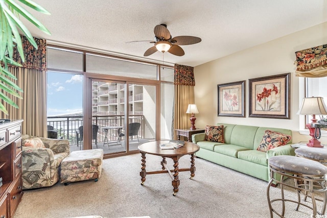 living room featuring carpet flooring, a textured ceiling, floor to ceiling windows, and ceiling fan