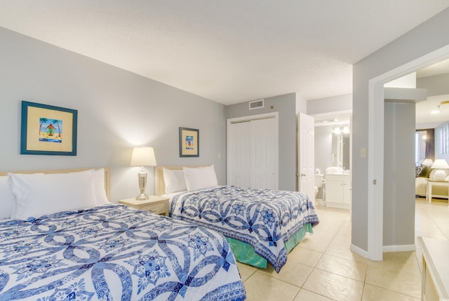 tiled bedroom featuring ensuite bath and a closet