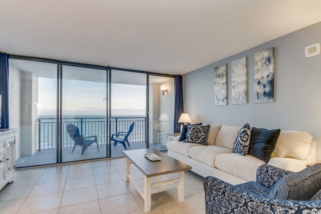 tiled living room featuring a water view and floor to ceiling windows