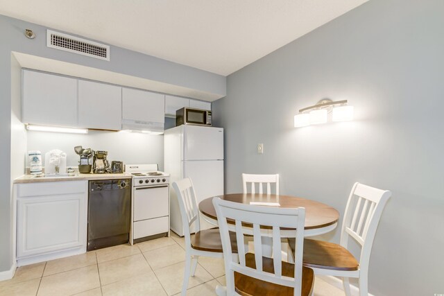 kitchen featuring white appliances, light tile patterned floors, sink, and white cabinets